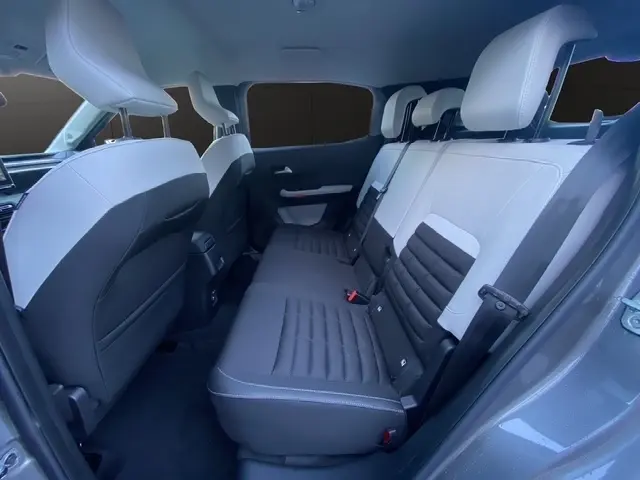 Vue intérieure côté droit sur la banquette arrière bicolore noire et blanche du Citroën C3 Aircross gris foncé 2026 hybride.