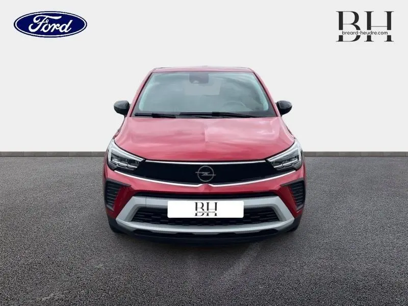 Vue avant d'un Opel Crossland 2023 rouge Kardio métallisé avec calandre noire et détails gris sur le pare-chocs.