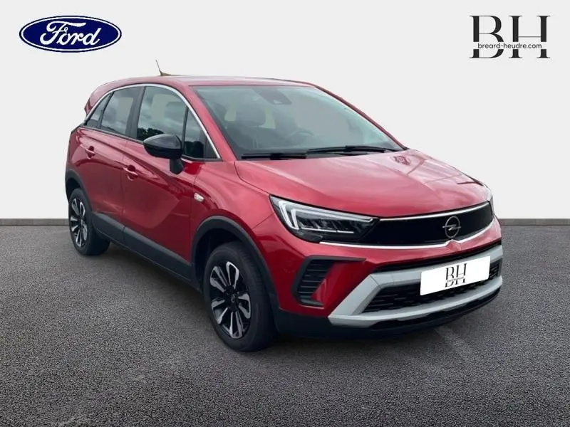 Opel Crossland rouge Kardio métallisé vue 3/4 avant droit avec jantes alu et calandre noire brillante.
