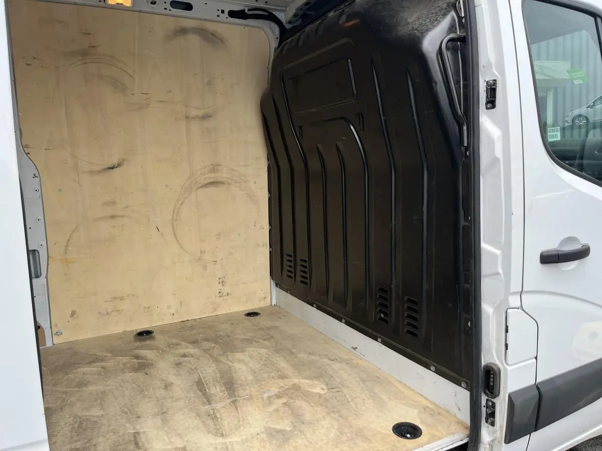 Vue intérieure de la zone de chargement du Renault Master blanc avec plancher et protection latérale en bois.