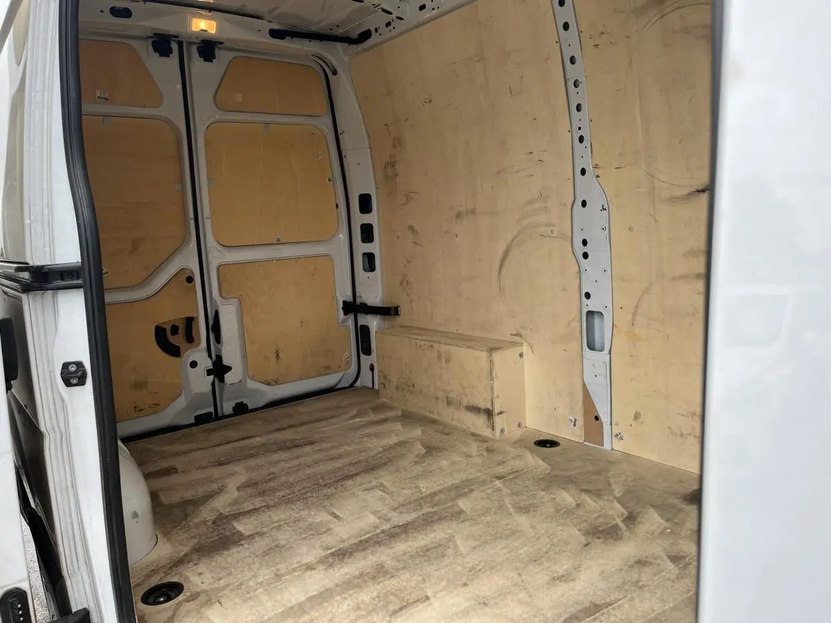 Vue intérieure arrière du Renault Master blanc 2023, montrant la zone de chargement avec plancher et protections latérales en bois.