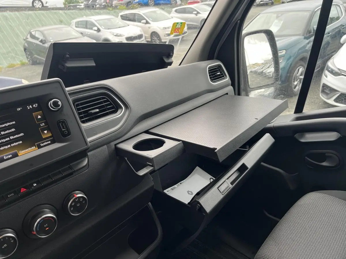 Intérieur côté passager du Renault Master blanc 2023, avec tablette rotative déployée et console ouverte.