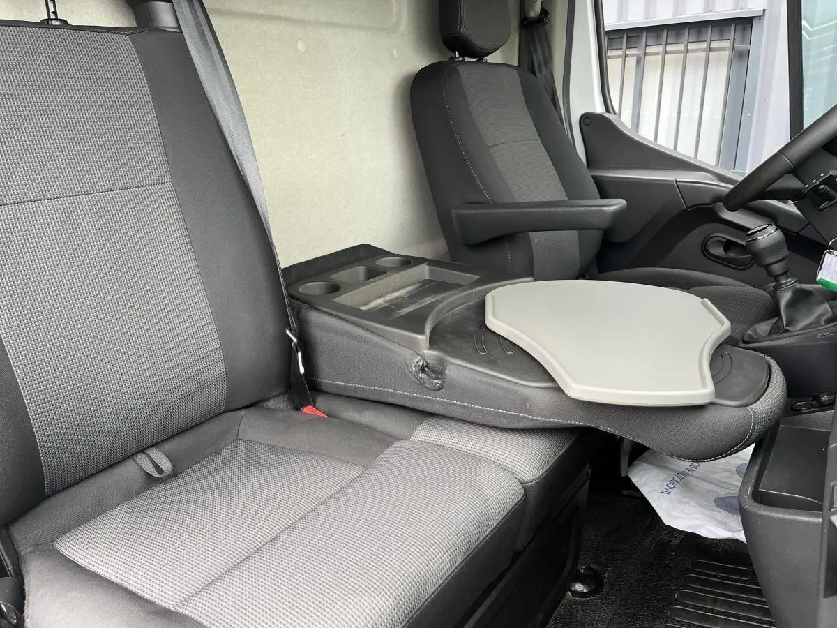 Intérieur du Renault Master 2023, vue côté droit sur banquette 2 places avec tablette rotative et siège conducteur noir.