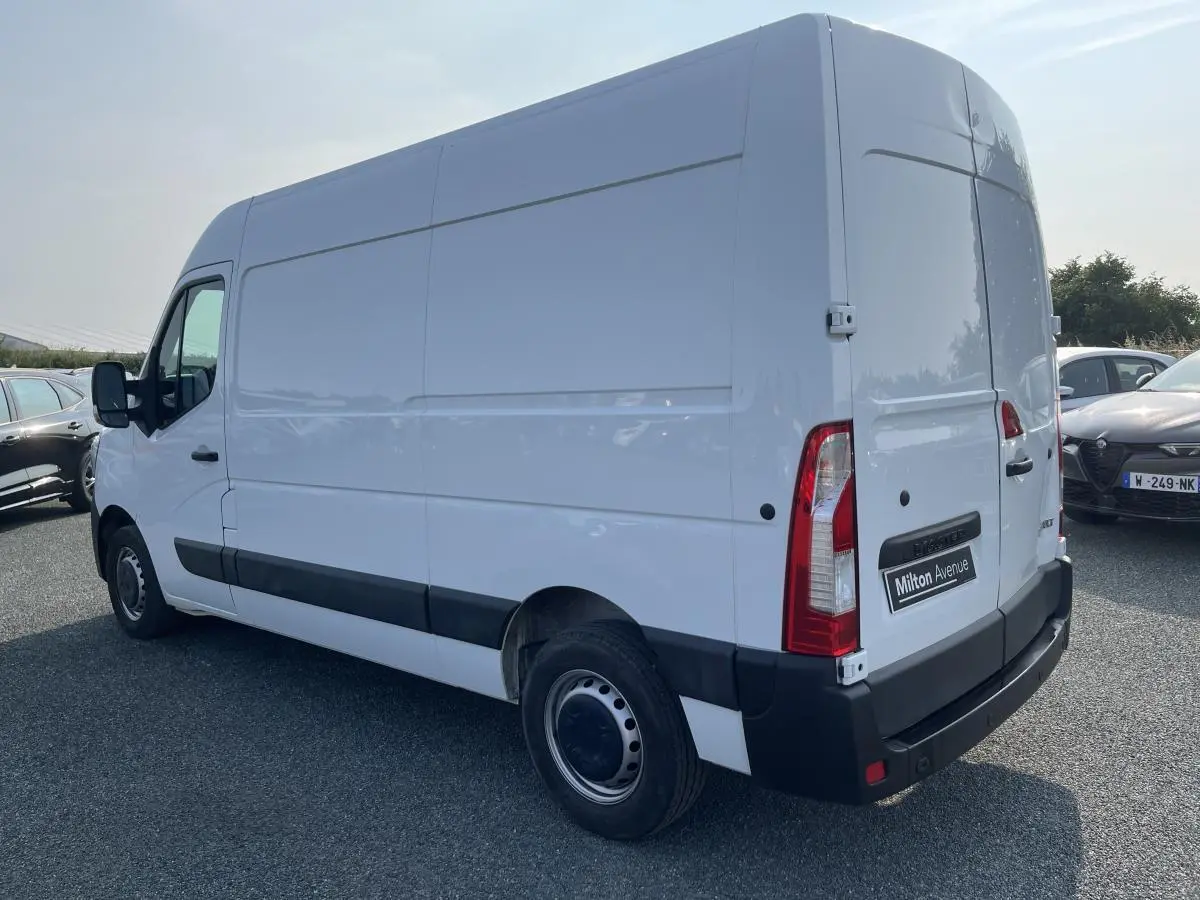 Renault Master blanc en vue 3/4 arrière droit, fourgon utilitaire avec protections latérales noires et roues tôlées.