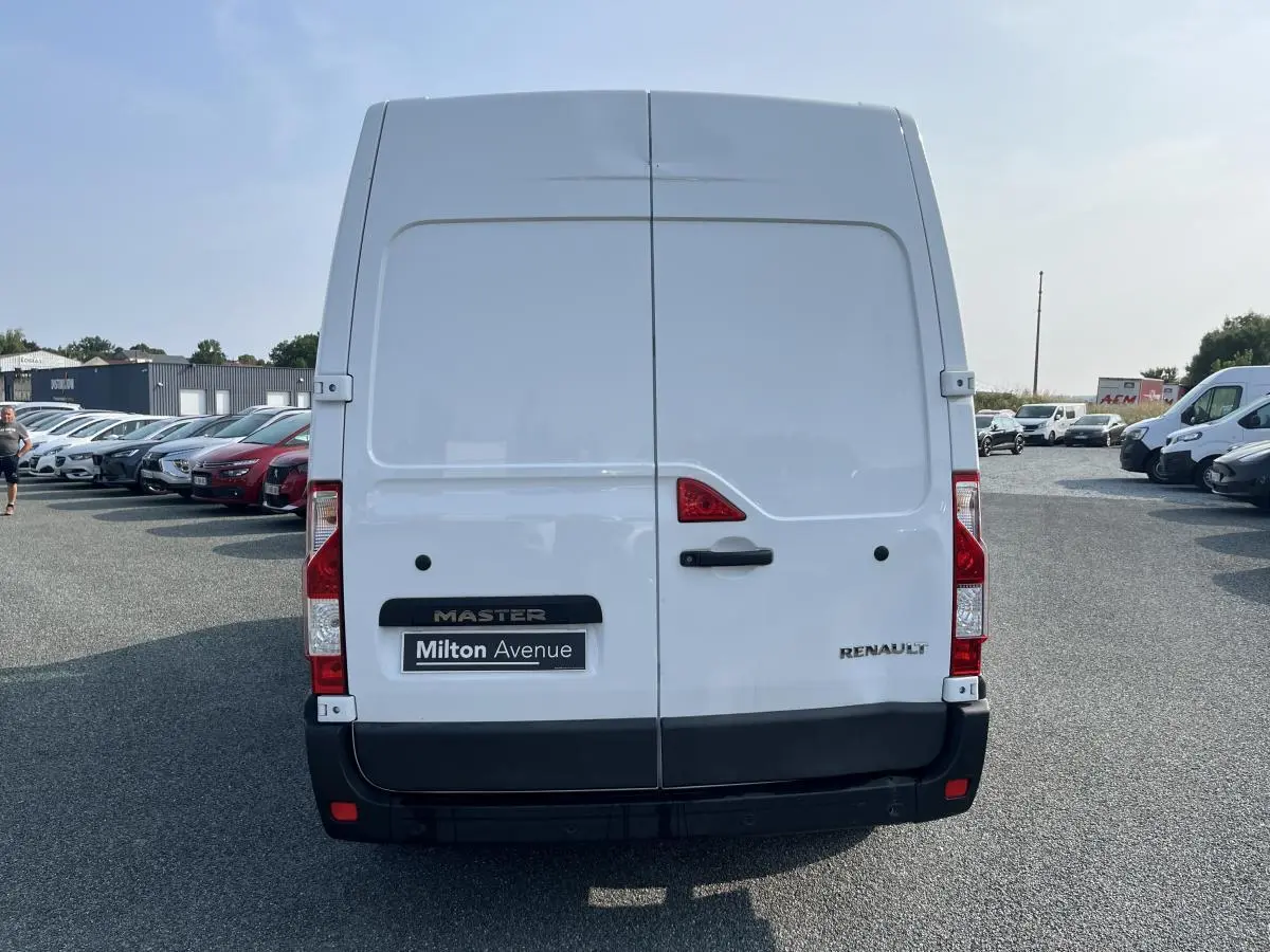 Vue arrière du Renault Master blanc avec portes battantes fermées et logo visible sur un parking extérieur.