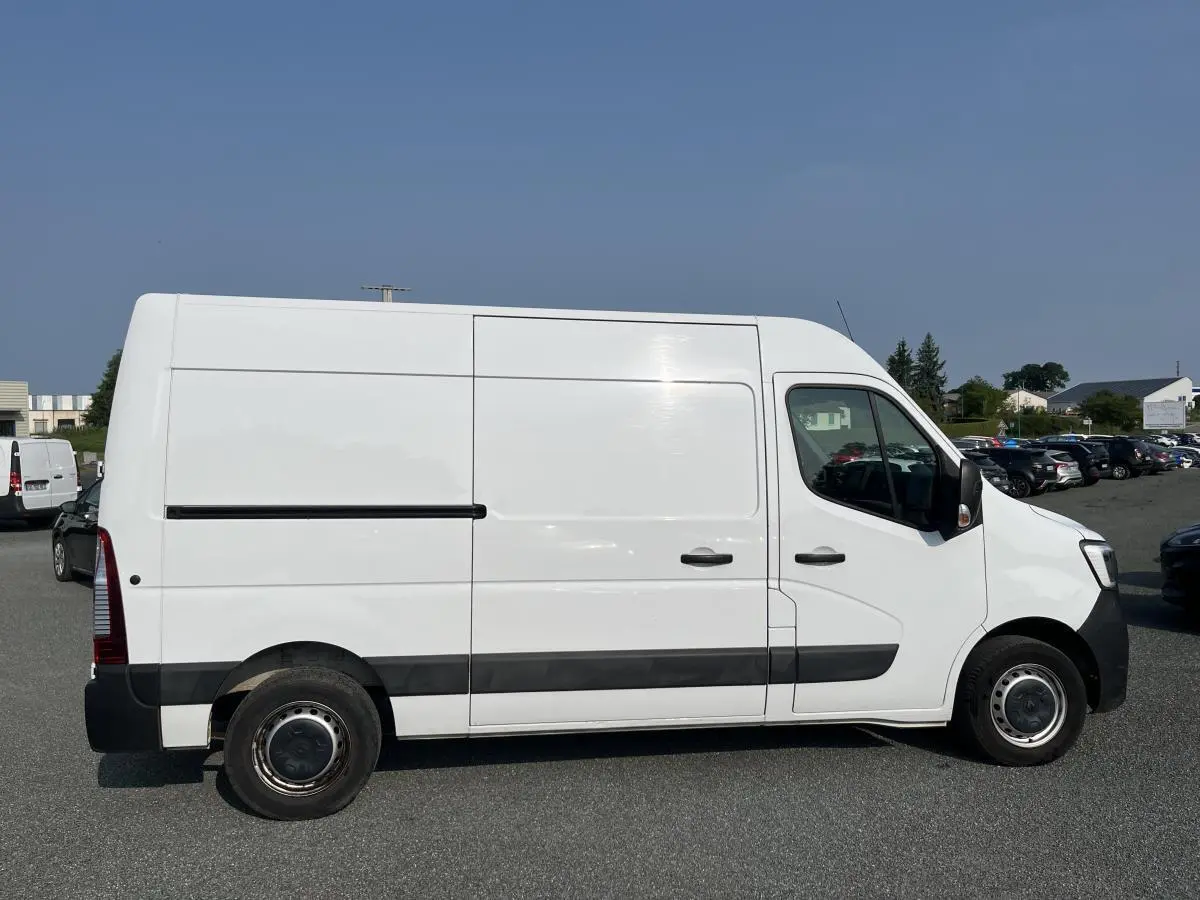 Renault Master blanc en vue profil côté gauche, fourgon utilitaire avec bande de protection noire et roues tôlées.