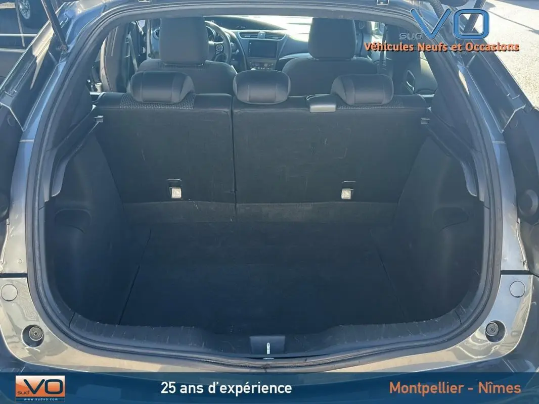 Coffre ouvert d'une Honda Civic gris 2015, vue arrière montrant l'espace de chargement et les sièges arrière.
