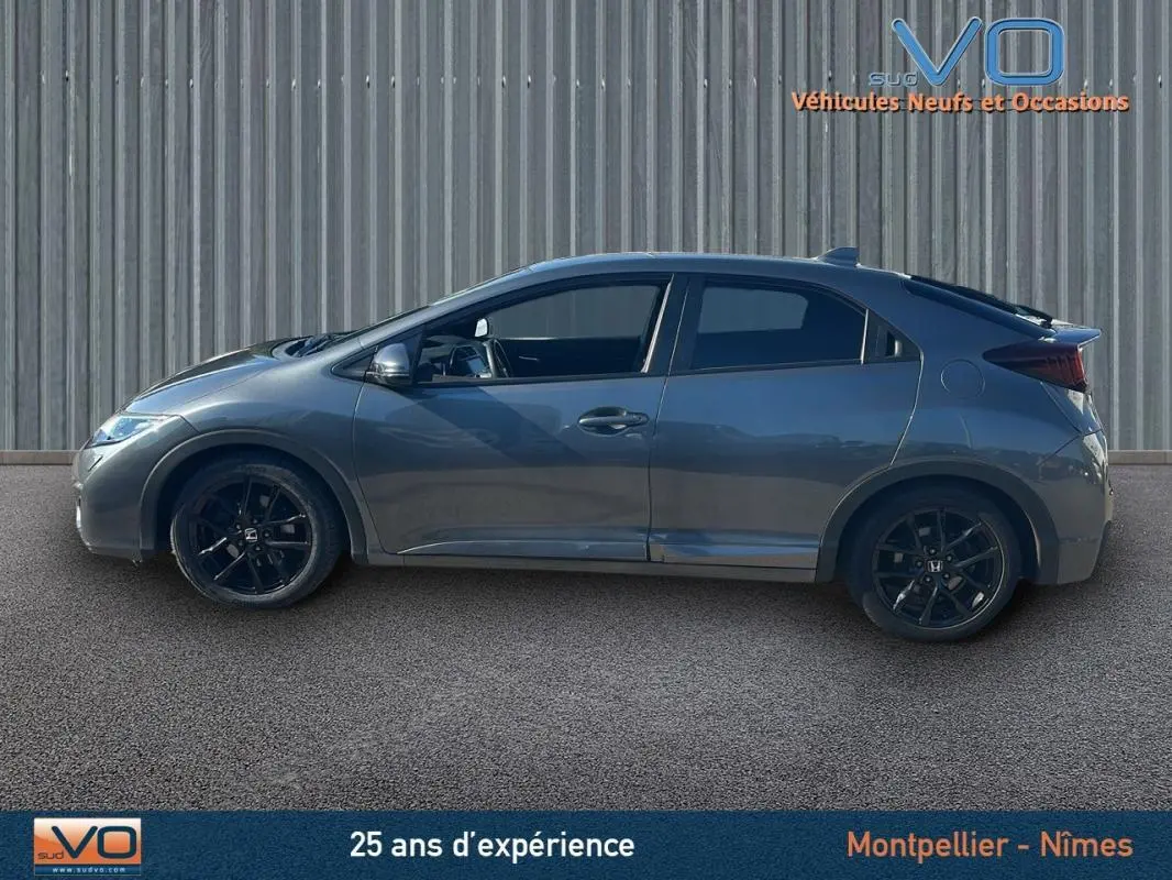 Profil côté gauche d'une Honda Civic 1.6 i-DTEC 120 Elegance gris 2015 avec jantes alliage noires et vitres surteintées.
