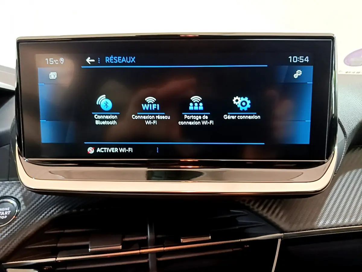 Écran tactile central affichant les options réseau dans l'habitacle d'une Peugeot 208 gris foncé 2022.