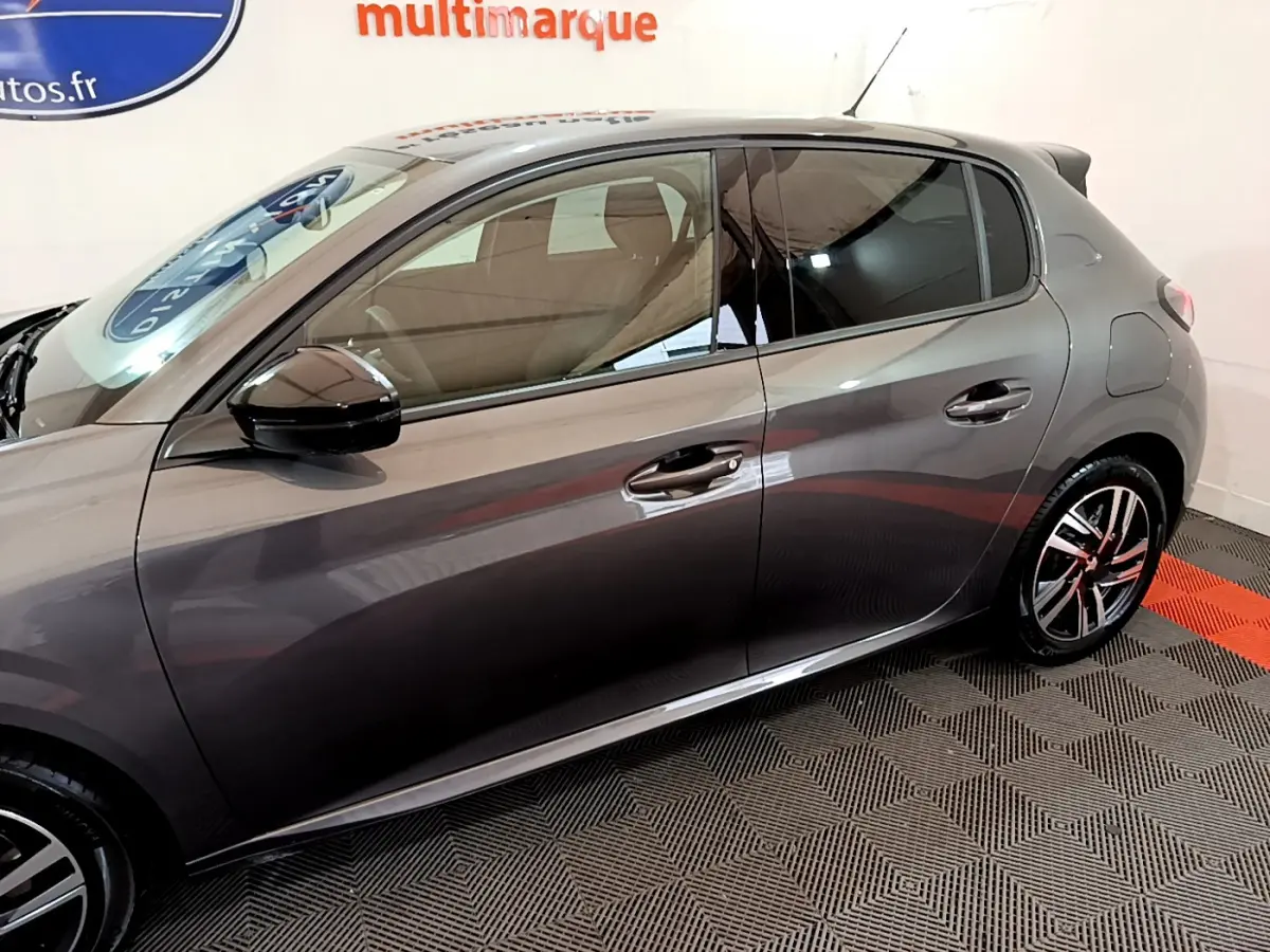 Profil côté gauche d'une Peugeot 208 gris foncé 2022 avec rétroviseurs noirs et jantes alliage distinctives.