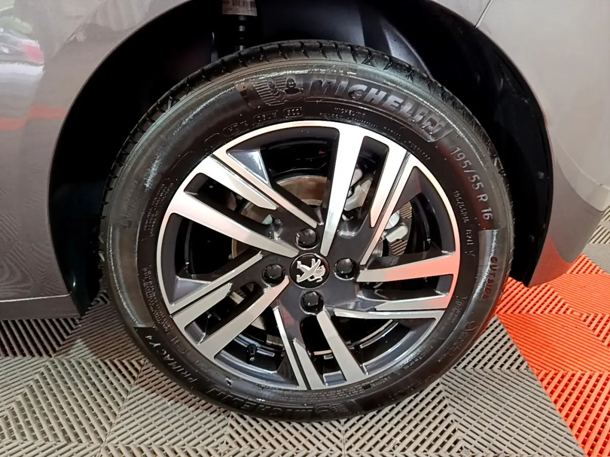 Gros plan sur la roue avant droite gris foncé d'une Peugeot 208 2022 avec jante alliage et pneu Michelin.