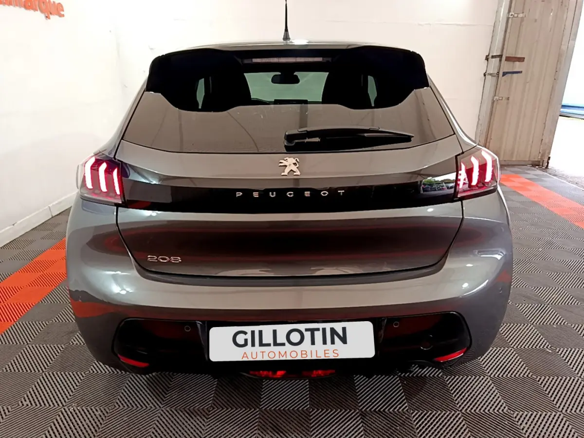 Vue arrière d'une Peugeot 208 gris foncé avec feux arrière LED distinctifs et logo centré sur le hayon.