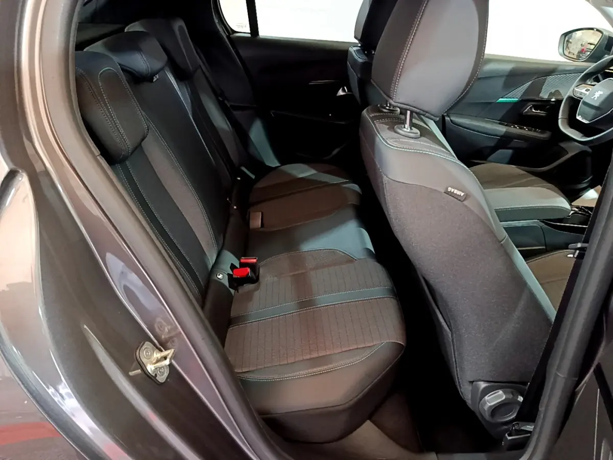 Vue intérieure côté gauche montrant les sièges arrière en tissu noir et gris du Peugeot 208 gris foncé 2022 Allure Pack.