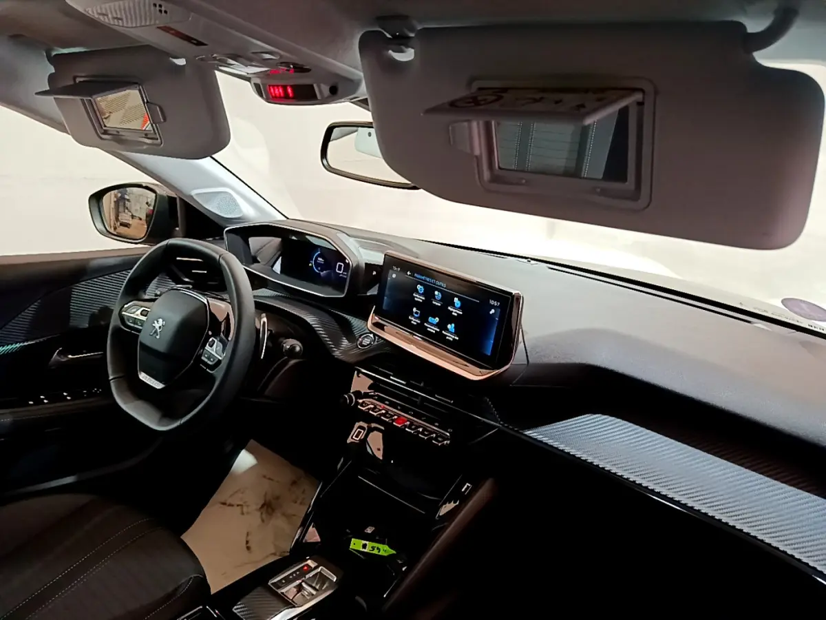 Vue intérieure côté conducteur du tableau de bord de la Peugeot 208 2022 avec écran tactile et volant cuir multifonction.