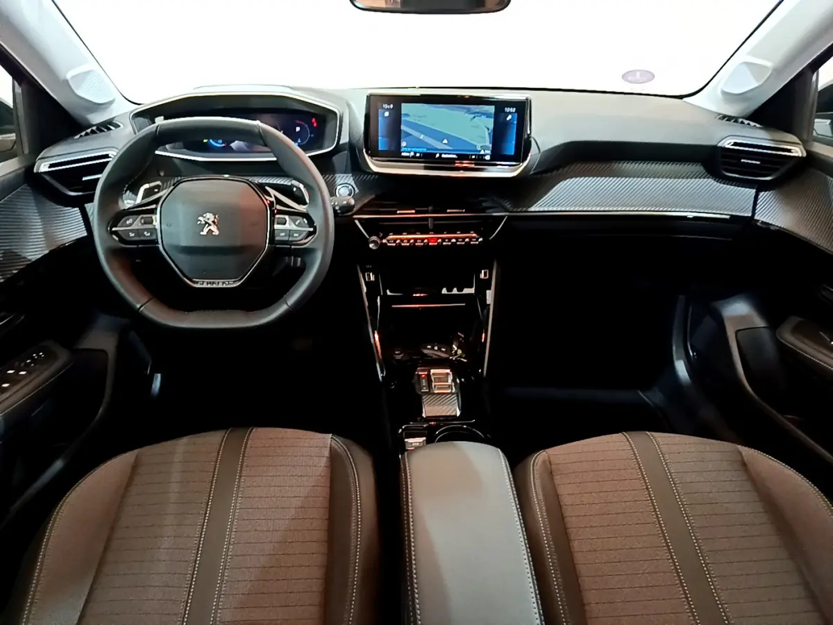Intérieur Peugeot 208 2022 vue avant du tableau de bord avec écran tactile et volant compact cuir noir.