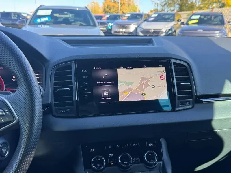 Vue intérieure du tableau de bord du Skoda Karoq gris 2025 avec écran tactile GPS et commandes climatisation visibles