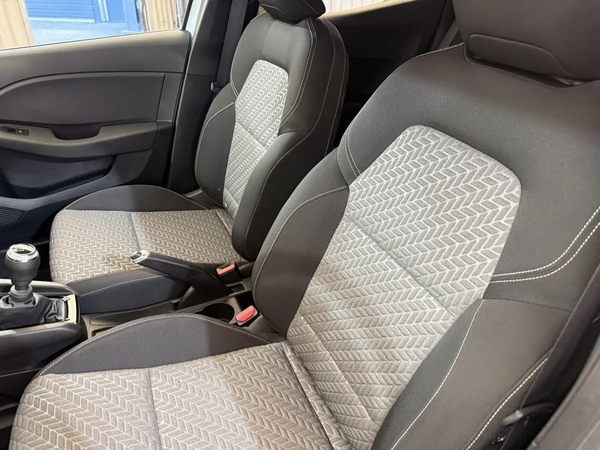 Vue intérieure rapprochée des sièges avant gris clair et foncé avec motifs géométriques de la Renault Clio Business 2023.