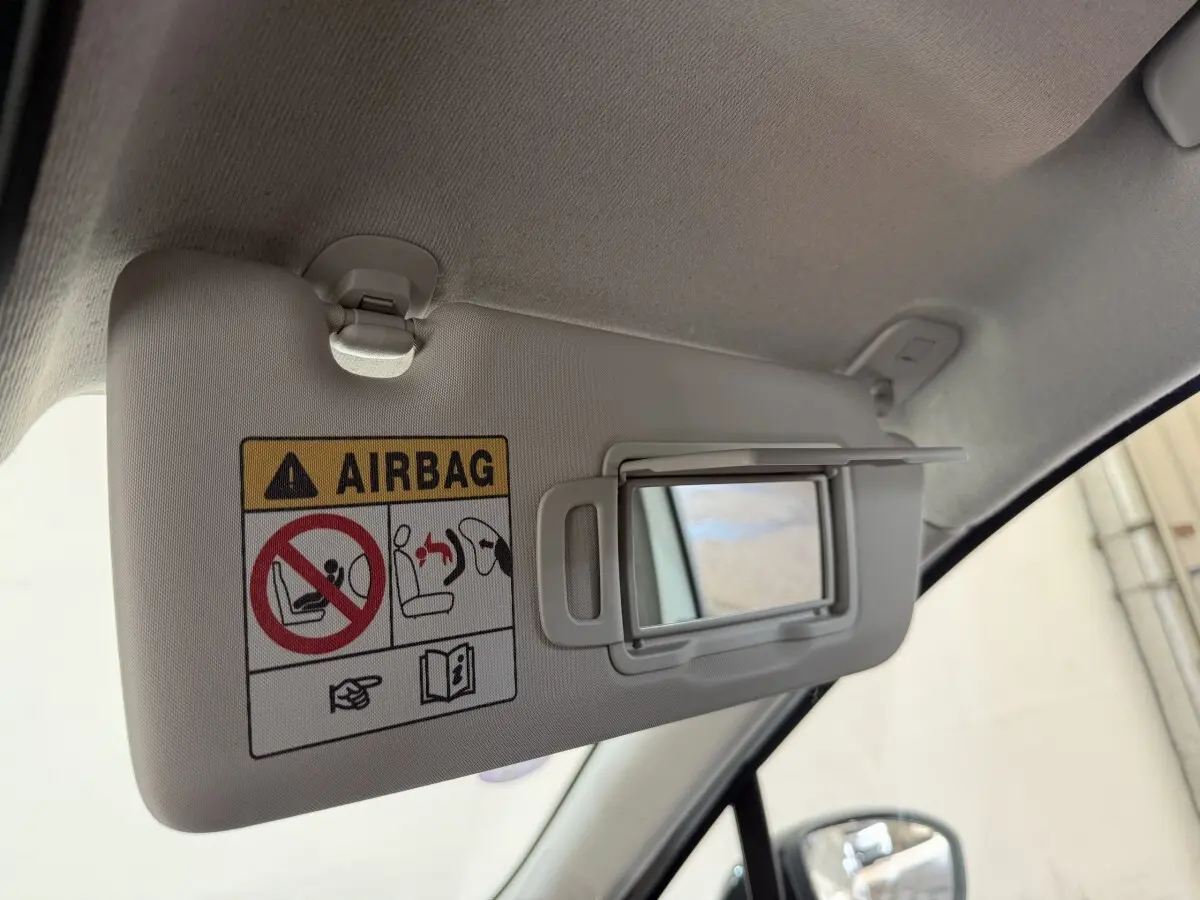 Détail du pare-soleil côté conducteur avec miroir intégré et avertissement airbag dans une Renault Clio blanche 2023.