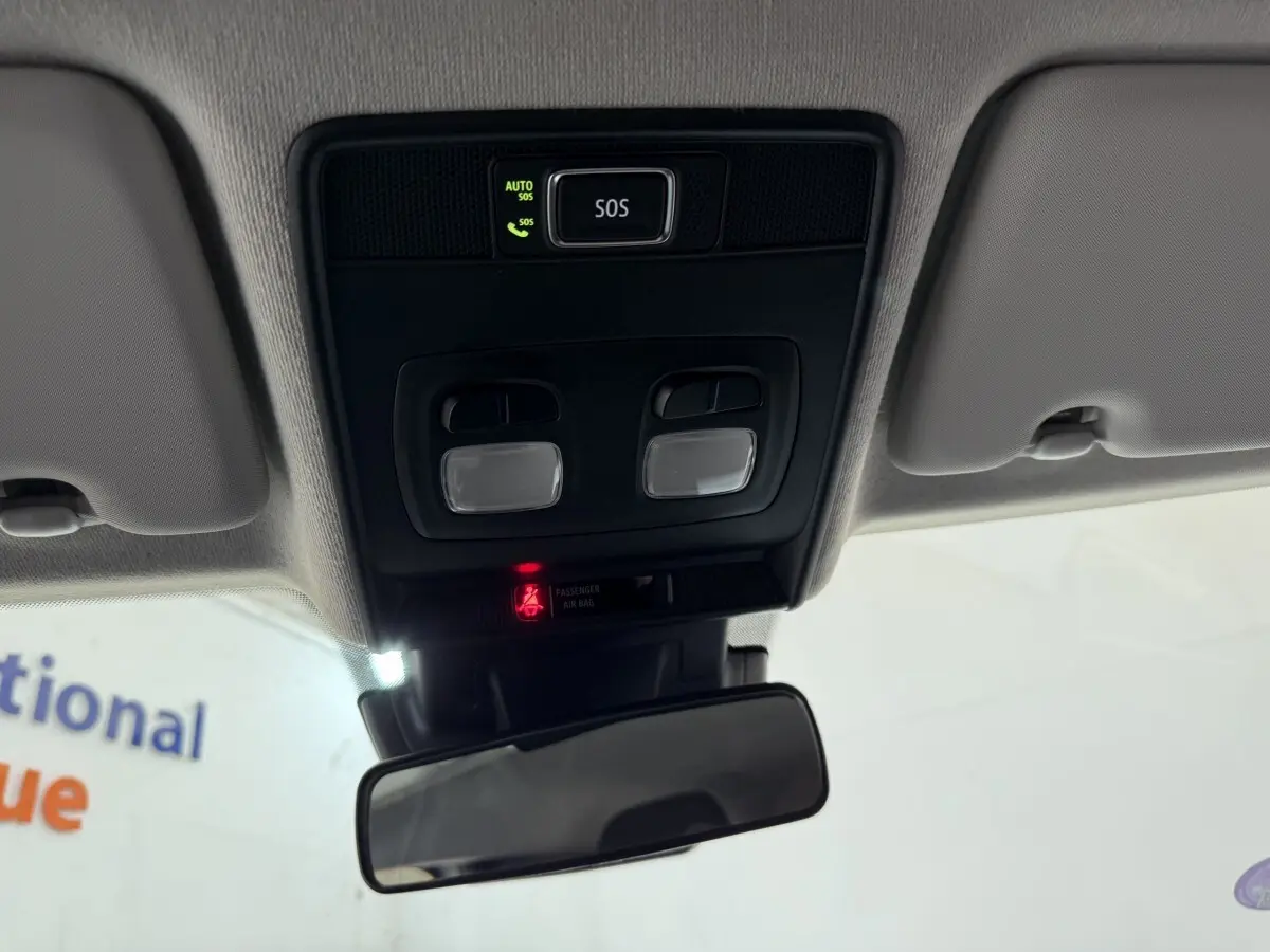 Vue intérieure du plafonnier avec commandes d’éclairage et bouton SOS dans une Renault Clio blanche 2023.