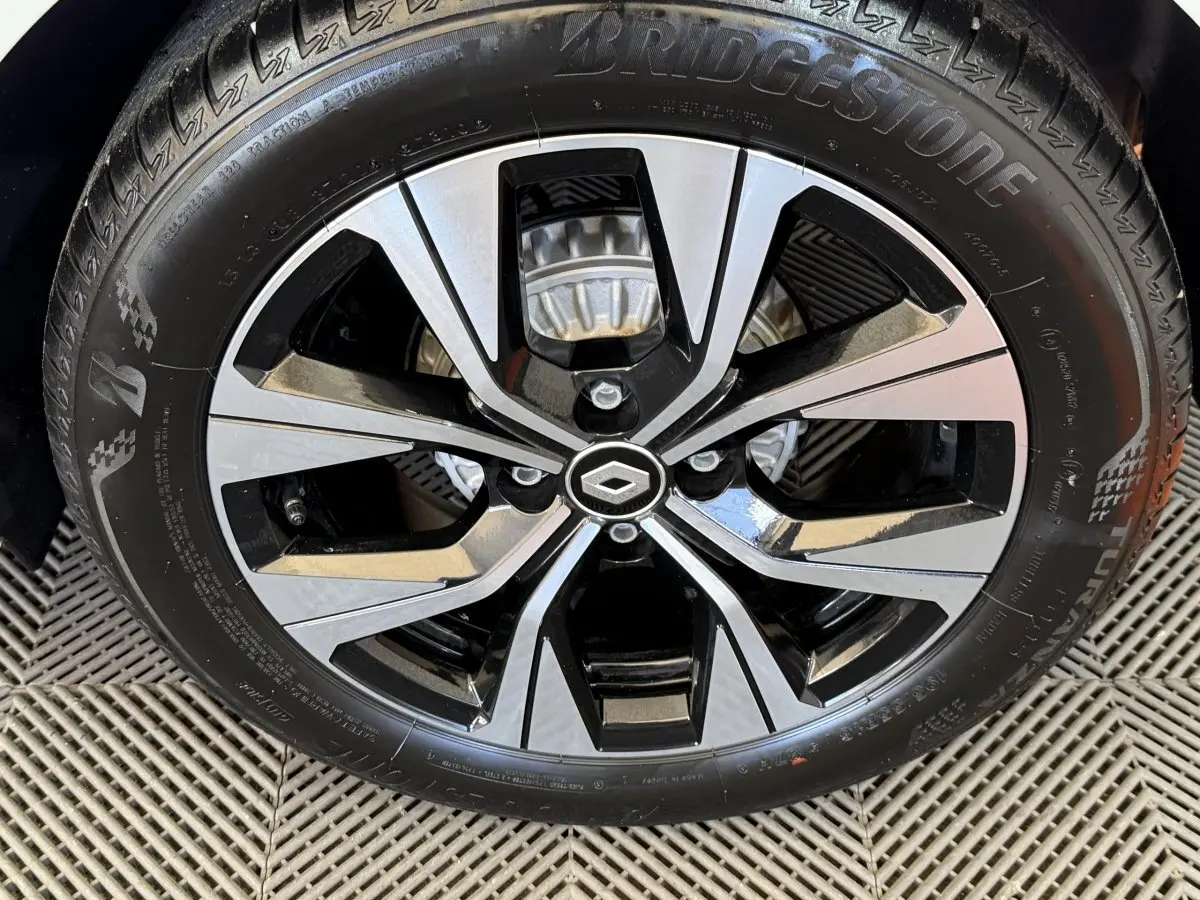 Gros plan sur la jante alliage bicolore noir et argent avec logo Renault au centre, montée sur pneu Bridgestone.