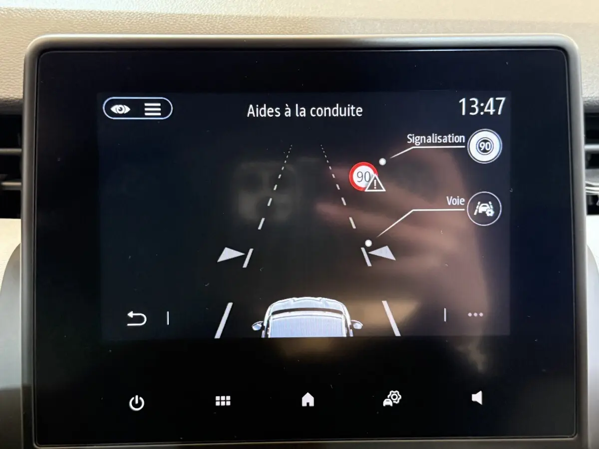 Écran tactile intérieur de la Renault Clio Business 2023 affichant les aides à la conduite et la signalisation routière.