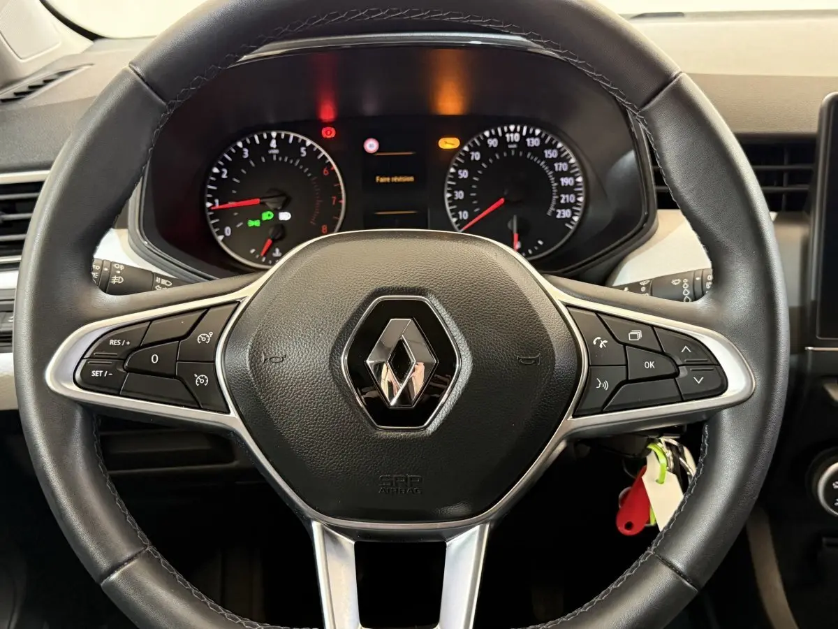 Vue rapprochée du volant cuir noir de la Renault Clio Business TCe 100 GPL 2023 avec tableau de bord et commandes intégrées.