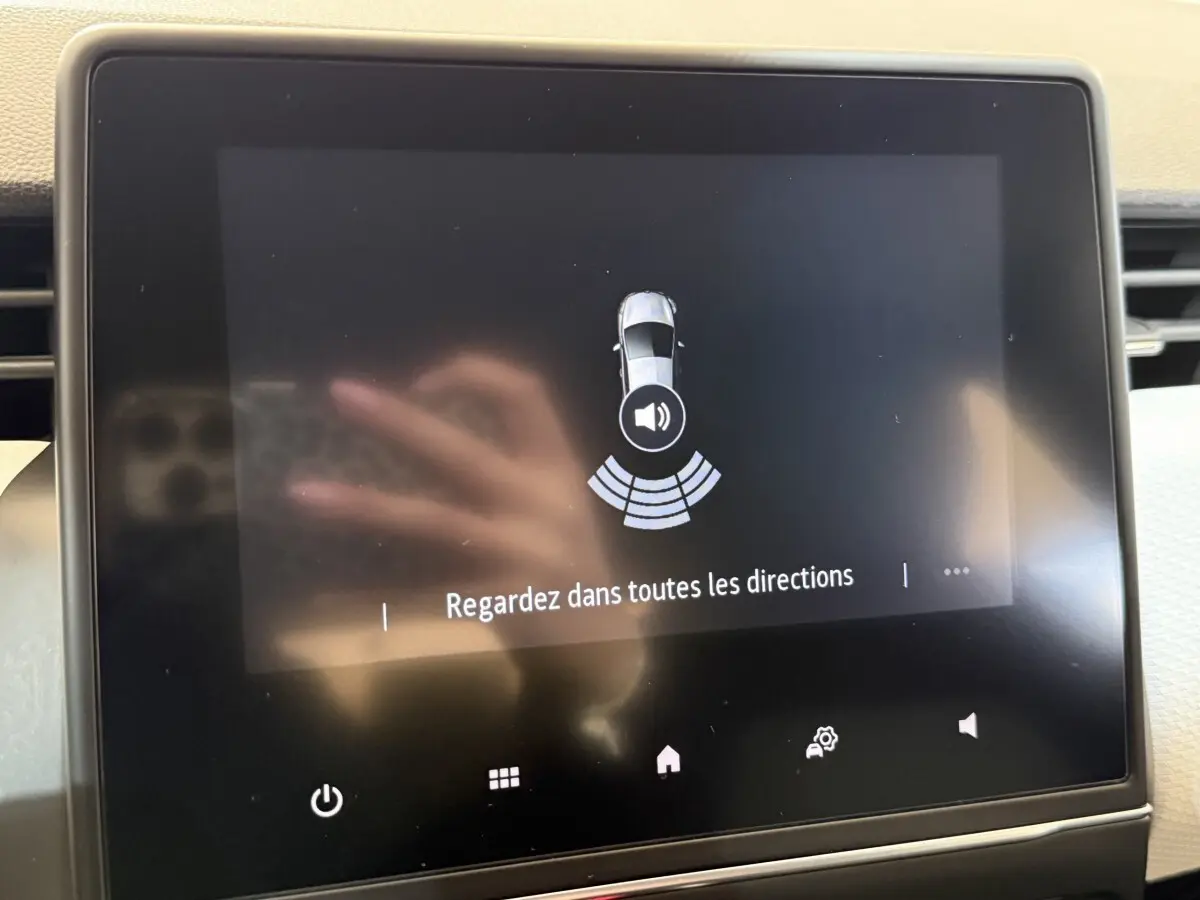 Écran tactile central de la Renault Clio Business blanc, affichant l'alerte de détection autour du véhicule.