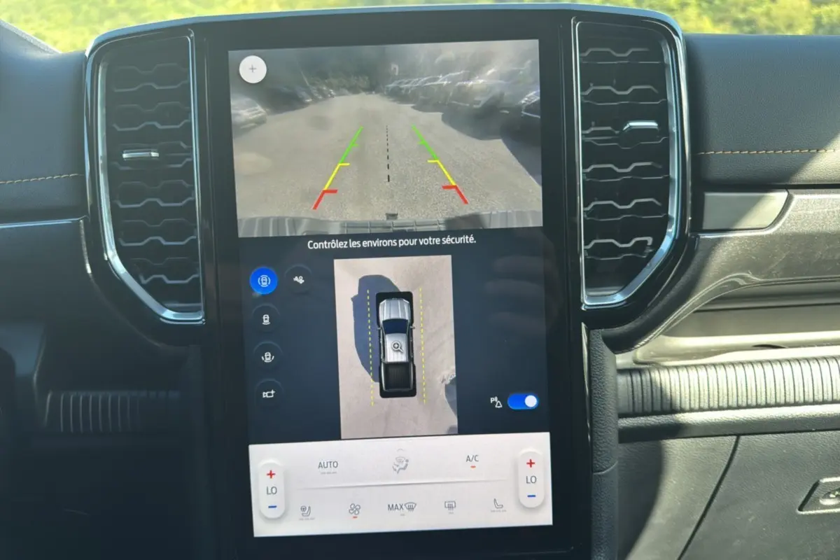 Écran tactile central du Ford Ranger 2025 montrant la caméra 360° et l’aide au stationnement, intérieur noir.