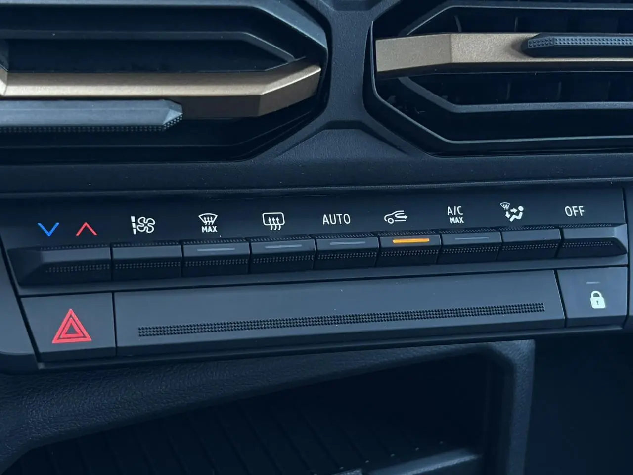 Gros plan sur la console centrale du Dacia Duster 2026 gris, montrant les commandes de climatisation automatique et les boutons fonctionnels.