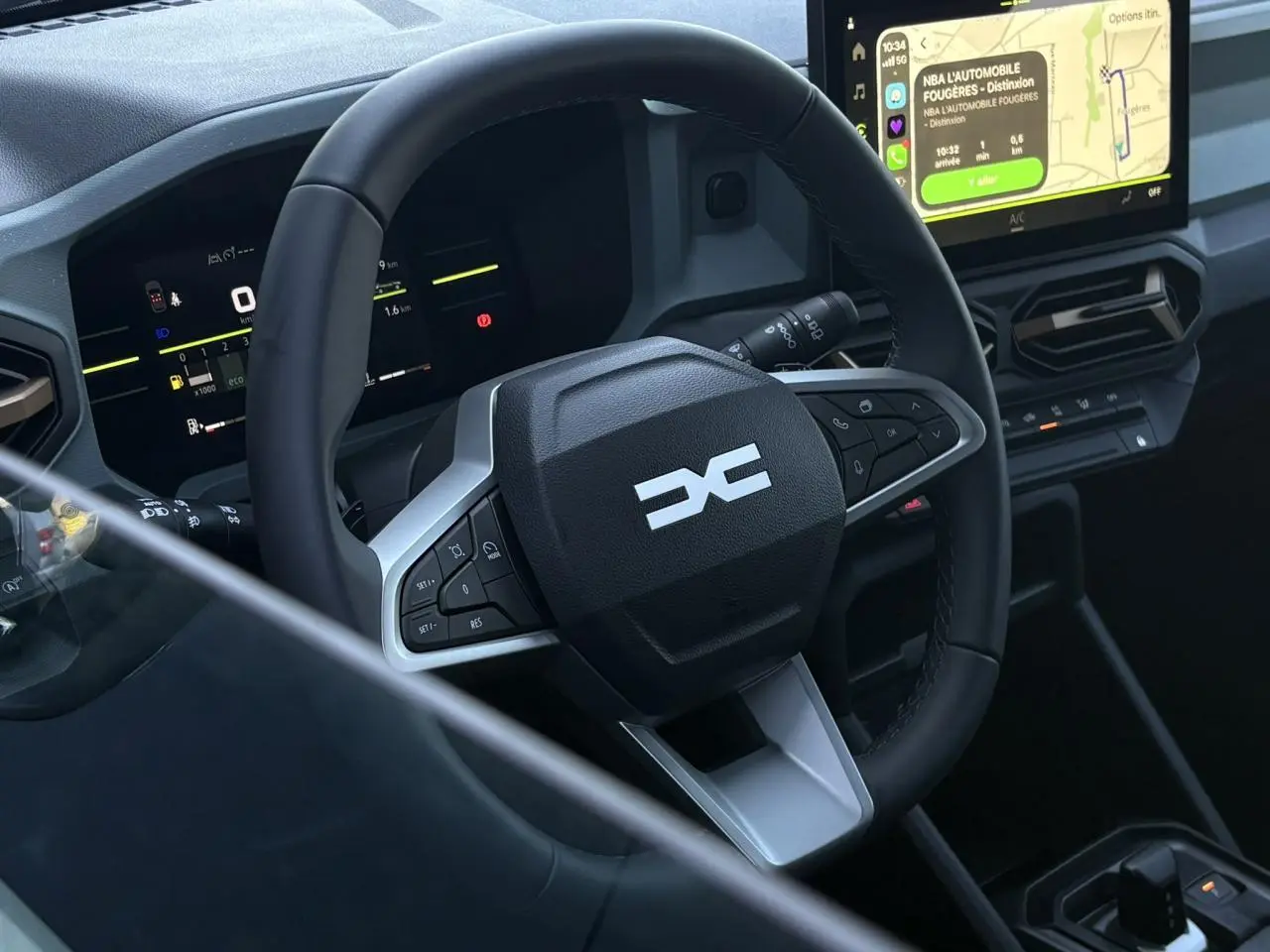 Vue rapprochée de l’intérieur du Dacia Duster 2026, volant multifonction noir avec tableau de bord digital et écran tactile.