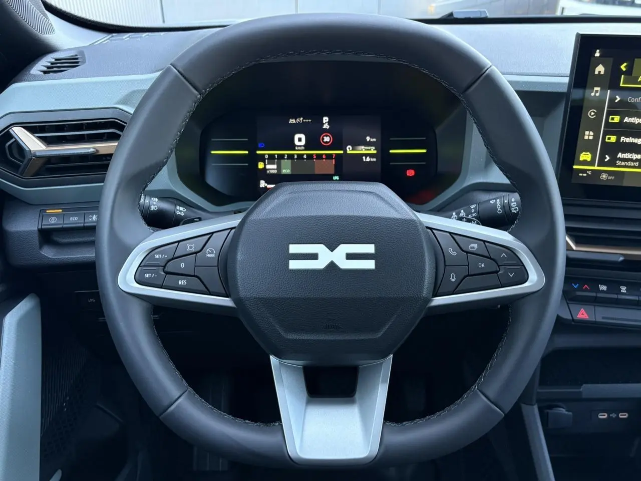 Vue rapprochée du volant noir du Dacia Duster 2026 avec tableau de bord digital et commandes intégrées.