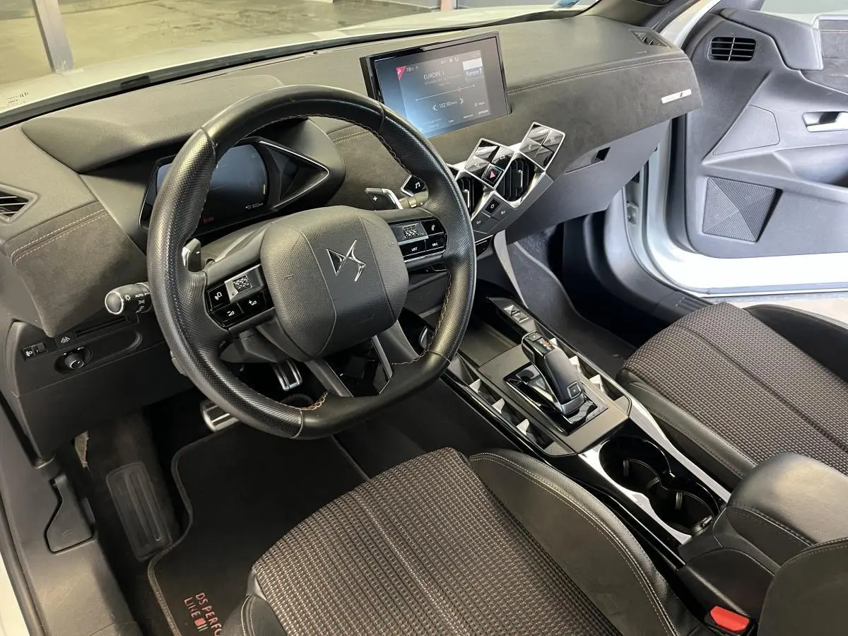 Intérieur avant droit du DS3 Crossback 2022 avec volant cuir noir, tableau de bord digital et sièges tissu Alcantara.