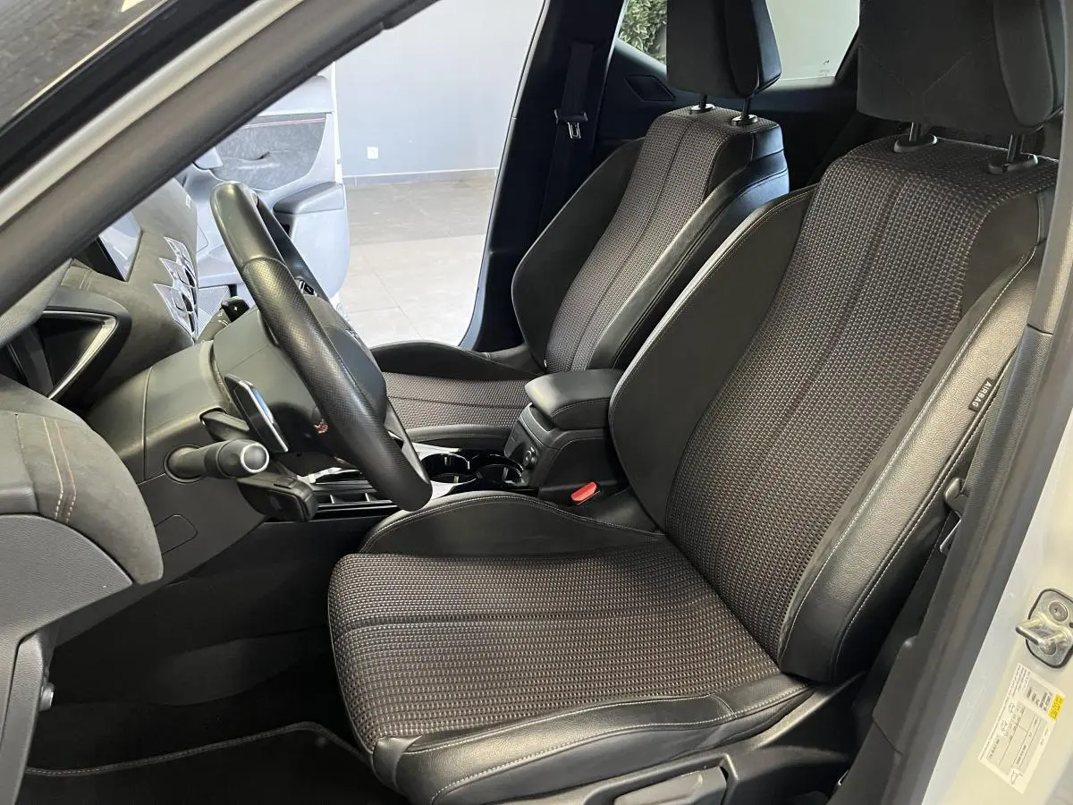 Vue intérieure côté conducteur du DS3 Crossback 2022 avec sièges tissu noir et alcantara, volant cuir et console centrale ouverte.