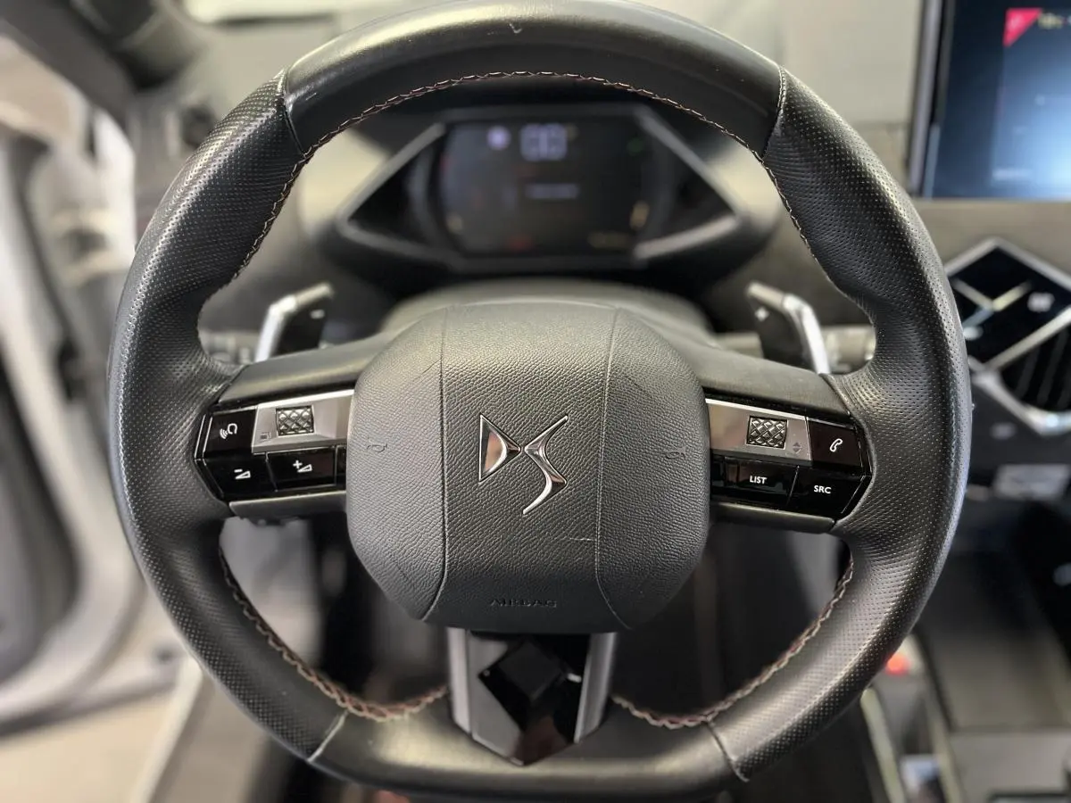 Volant en cuir noir avec surpiqûres Carmin et Or du DS3 Crossback 2022 vu de face, mettant en valeur les commandes intégrées.