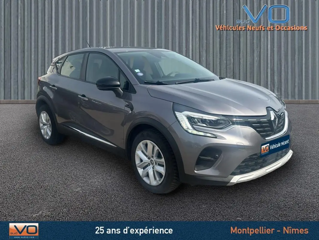 Renault Captur TCe 100 Business gris vu en 3/4 avant droit, avec phares LED et jantes alliage visibles.