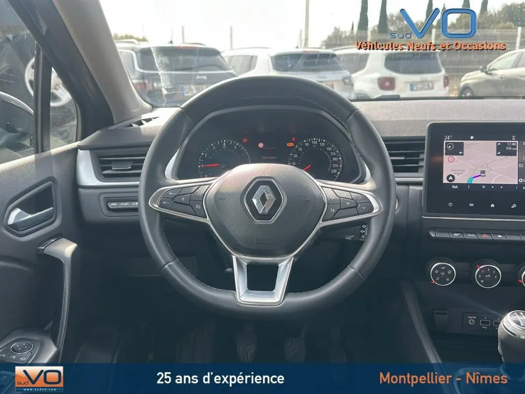 Vue intérieure centrée sur le volant d'un Renault Captur gris 2020 avec tableau de bord et écran tactile visible.