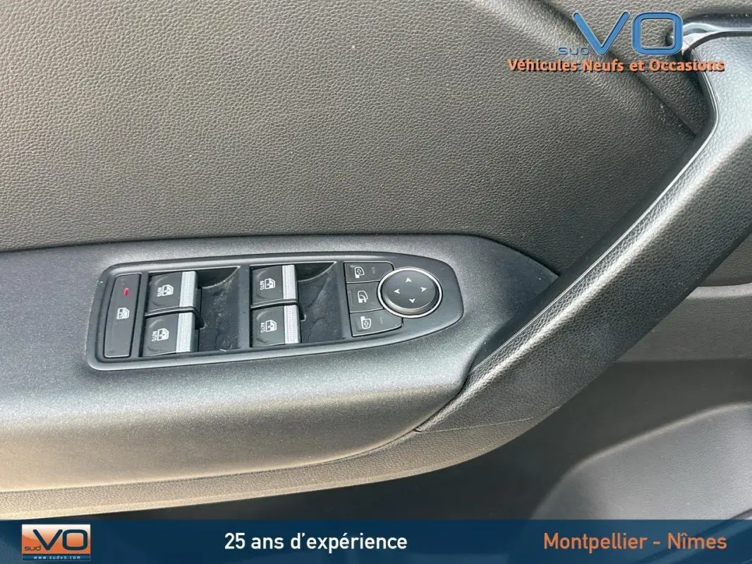 Panneau de porte côté gauche du Renault Captur gris 2020, avec commandes des vitres électriques et rétroviseurs réglables.