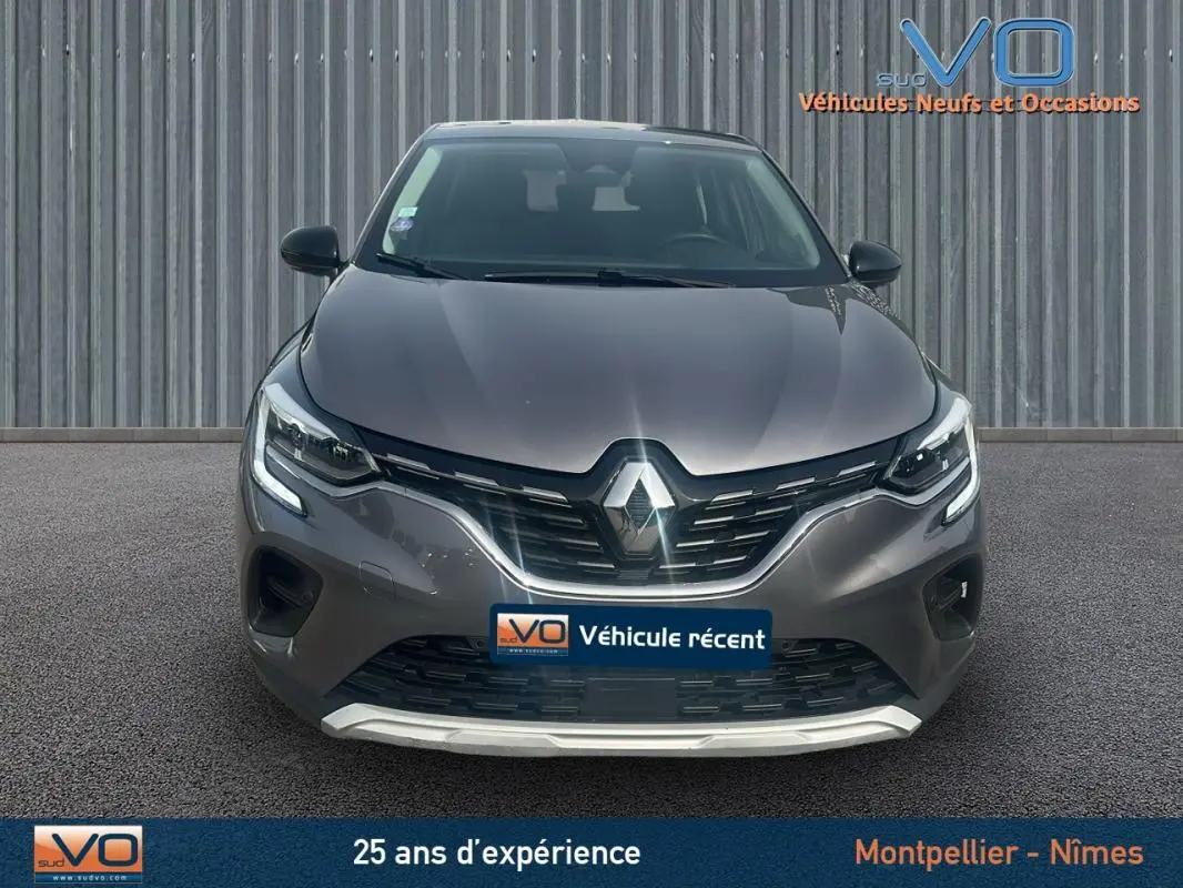 Vue frontale d'un Renault Captur TCe 100 Business gris 2020 avec feux LED allumés et calandre noire brillante.