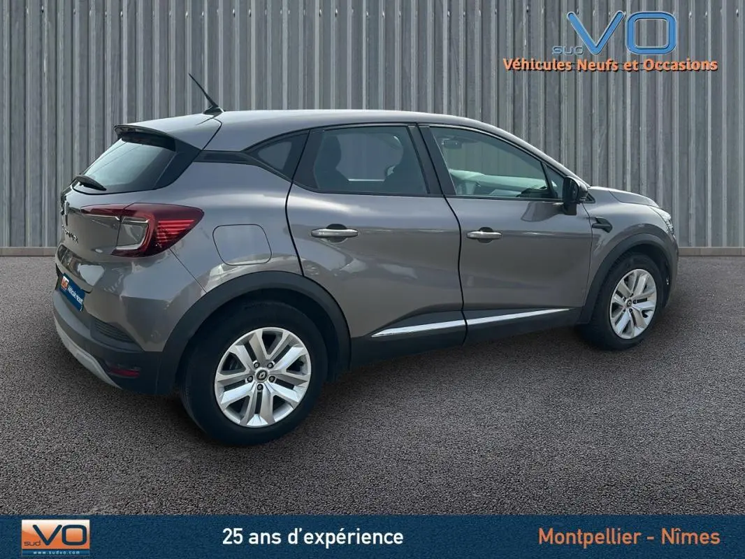Renault Captur TCe 100 Business gris vu de profil côté droit, avec jantes alliage et feux arrière visibles.