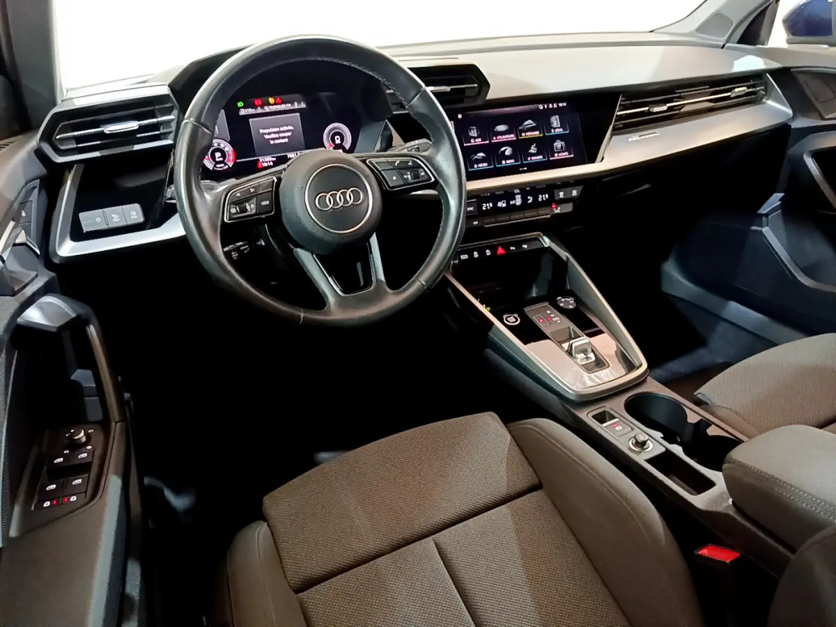 Vue intérieure côté conducteur de l'Audi A3 35 TFSI 150 MHEV Business Line 2023, tableau de bord et écran tactile visibles.