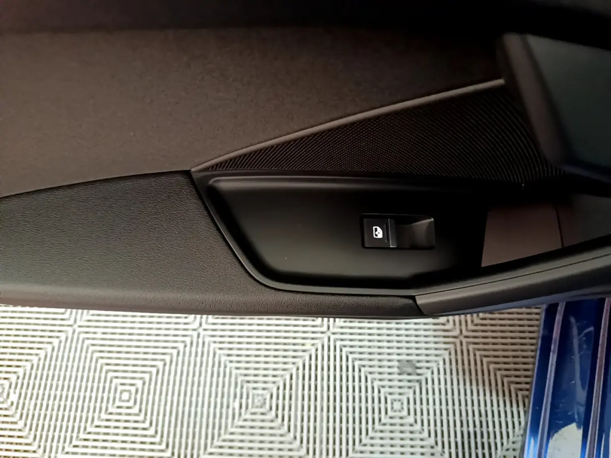 Détail de la commande de verrouillage sur la porte côté gauche d'une Audi A3 bleu 2023.