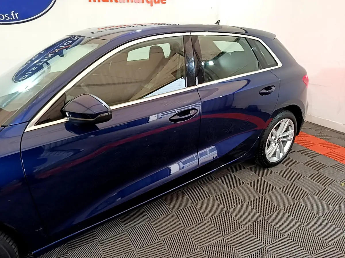 Vue latérale côté gauche d'une Audi A3 bleu profond, mettant en valeur les lignes élégantes et les jantes alliage.