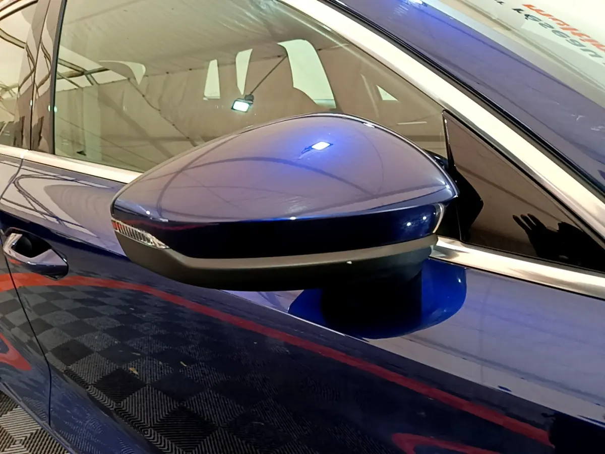 Rétroviseur côté gauche bleu brillant de l'Audi A3 35 TFSI 150 MHEV Business Line 2023 avec clignotant intégré.