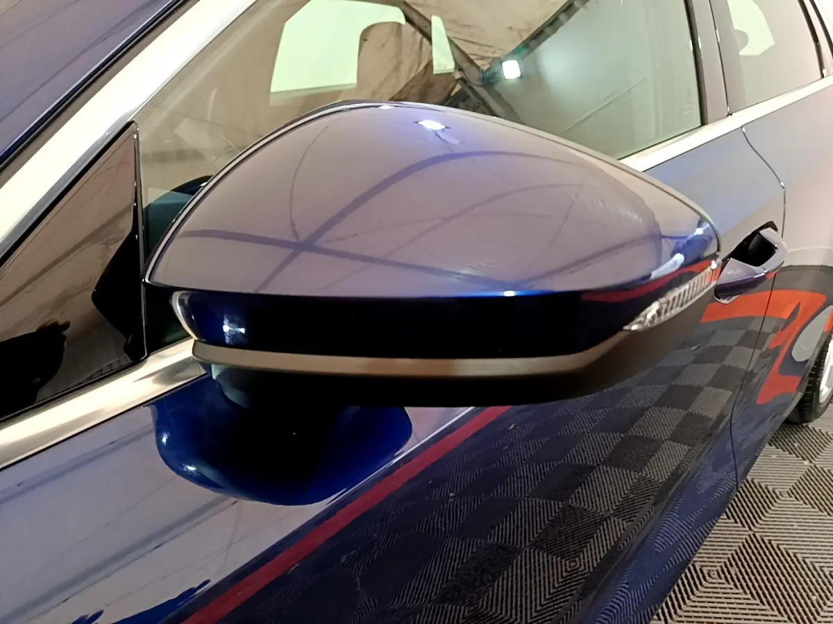 Rétroviseur côté gauche bleu brillant de l'Audi A3 35 TFSI 150 MHEV Business Line 2023 avec clignotant intégré.