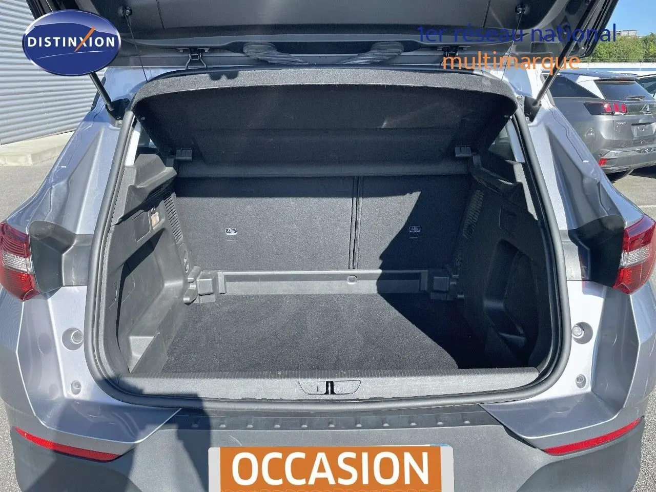 Coffre ouvert d'un Opel Grandland X gris quartz métal, vue arrière mettant en valeur l'espace de chargement vide.