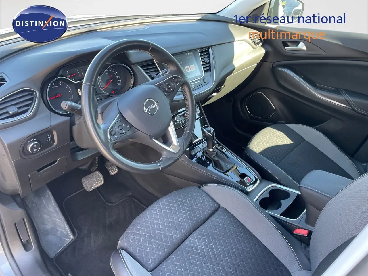 Intérieur de l'Opel Grandland X 2021 en vue côté conducteur, avec tableau de bord noir et sièges tissu gris et noir.