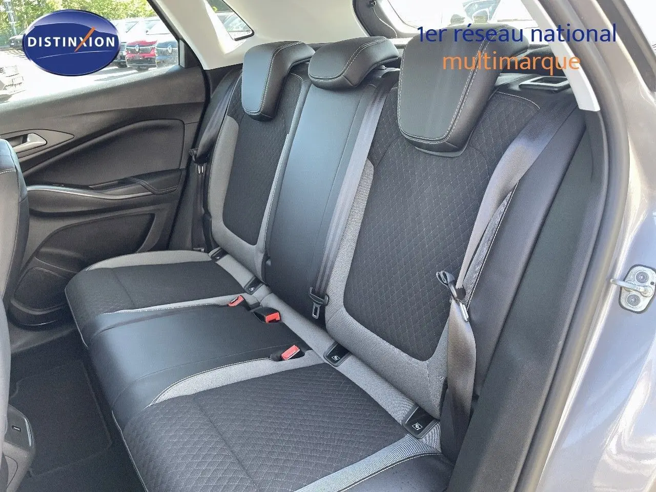 Vue intérieure arrière droite des sièges arrière en tissu noir et gris d'un Opel Grandland X gris quartz métal.