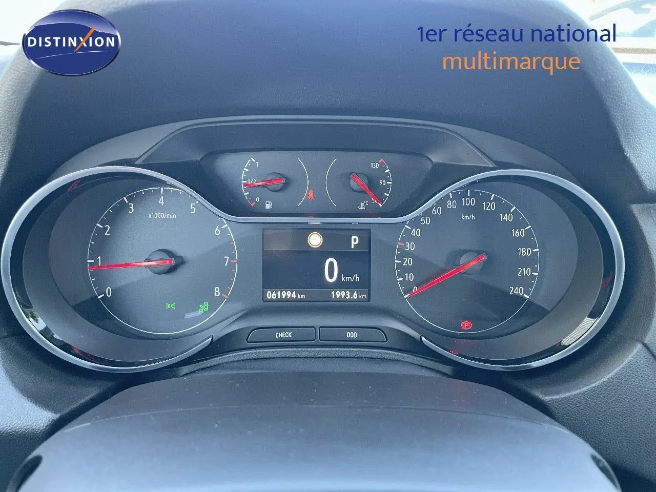 Vue rapprochée du tableau de bord digital de l'Opel Grandland X gris quartz, affichant 0 km/h et 61994 km au compteur.