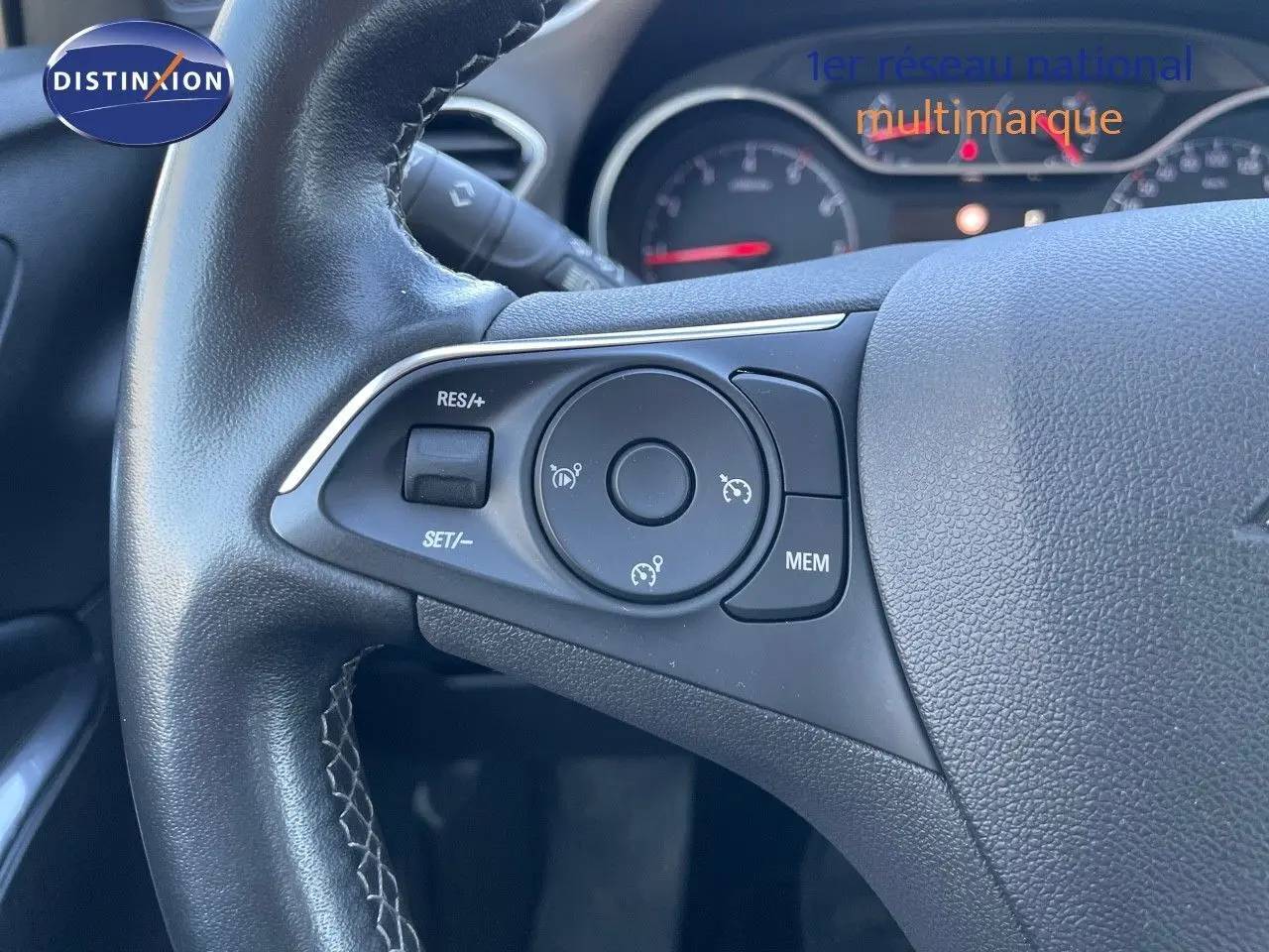 Gros plan sur le volant noir de l'Opel Grandland X 2021, montrant les commandes de régulateur de vitesse.