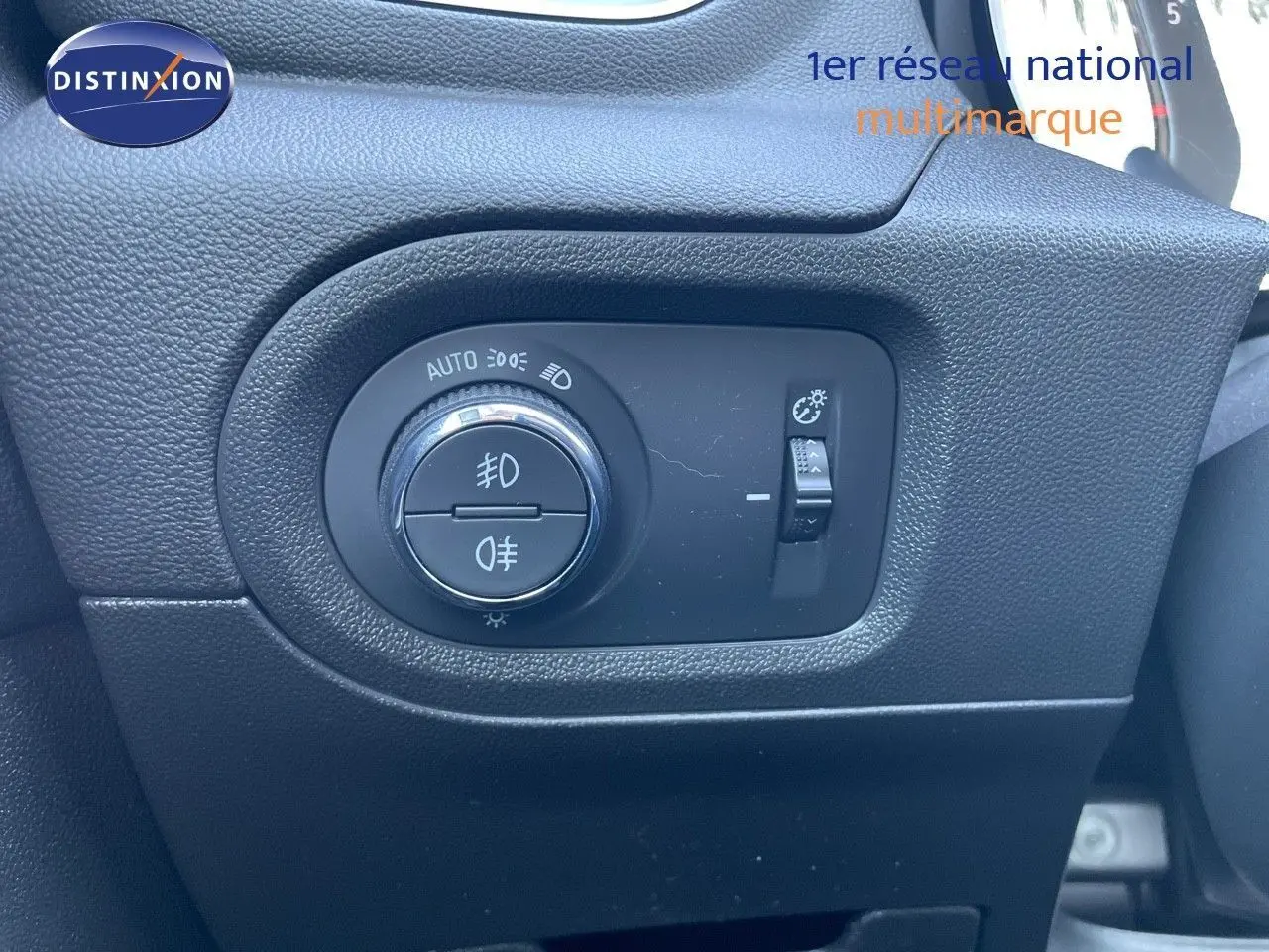 Gros plan sur le bouton de commande des phares dans l'habitacle d'un Opel Grandland X gris quartz metal.